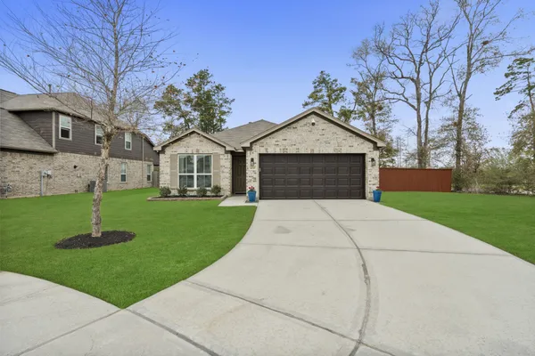 a front view of a house with a garden and trees