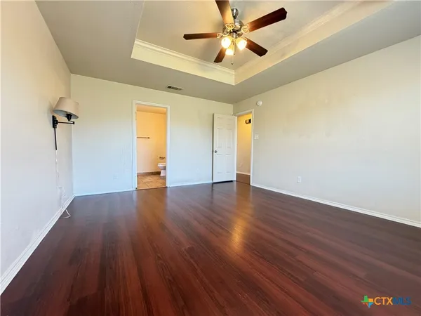 a view of an empty room with wooden floor