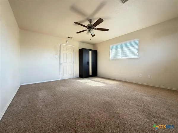 a view of a livingroom with a ceiling fan and window