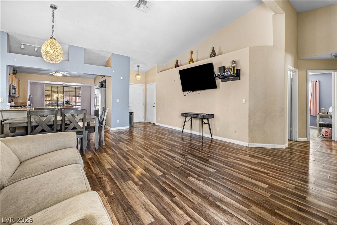 1624 Palmae Way Las Vegas, NV 89128 - Photo 3 of 18 This living area features rich wood flooring and soaring vaulted ceilings, creating an open, inviting atmosphere.