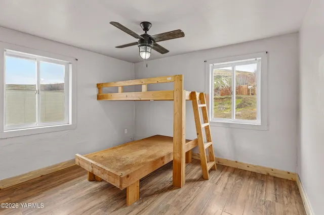 a view of a hallway with wooden floor and a dining room