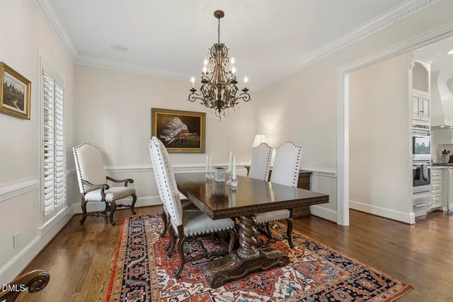 a bed room with a bed a dresser and a chandelier