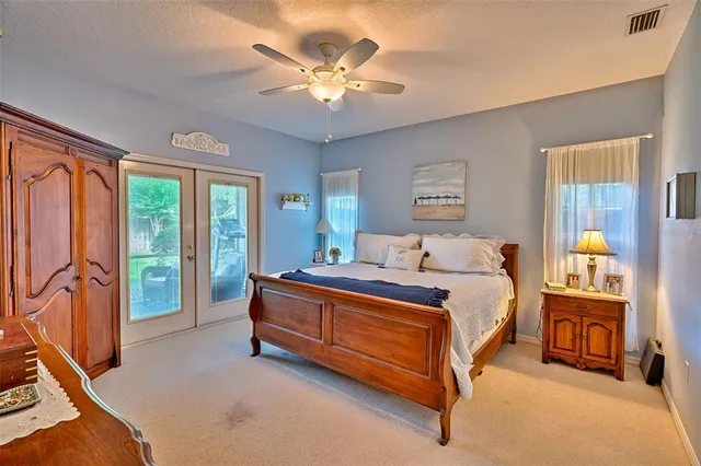 a spacious bedroom with a bed and a chandelier