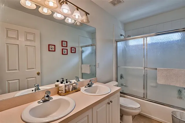 a bathroom with a sink toilet a mirror and shower