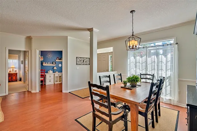a view of a dining room and livingroom with furniture wooden floor a chandelier