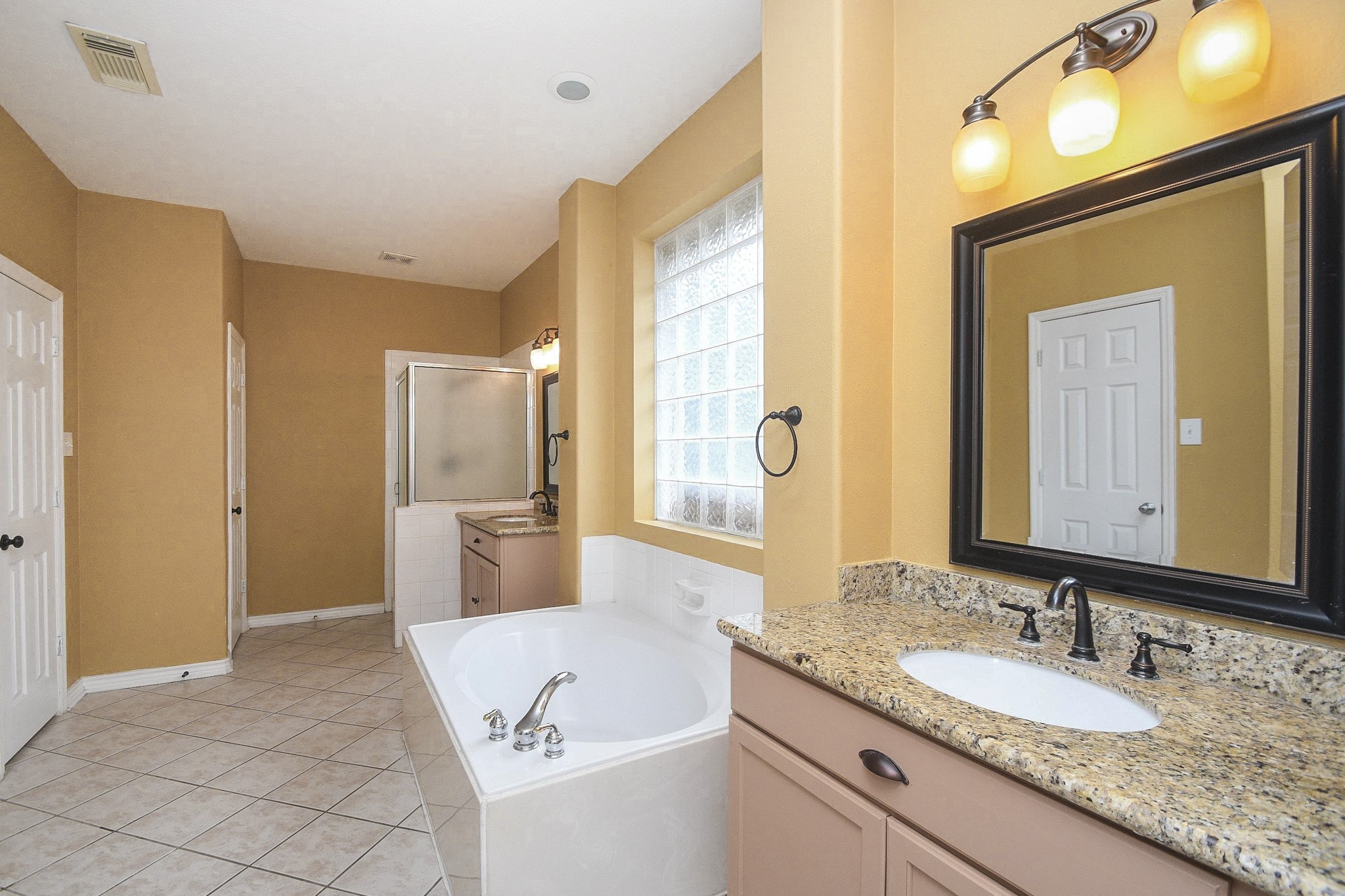5602 Walkabout Way Katy, TX 77450 - Photo 20 of 33 a spacious bathroom with a granite countertop sink and a mirror