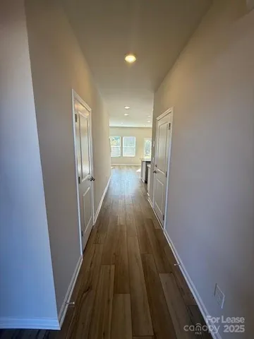 a view of a hallway with wooden floor and staircase