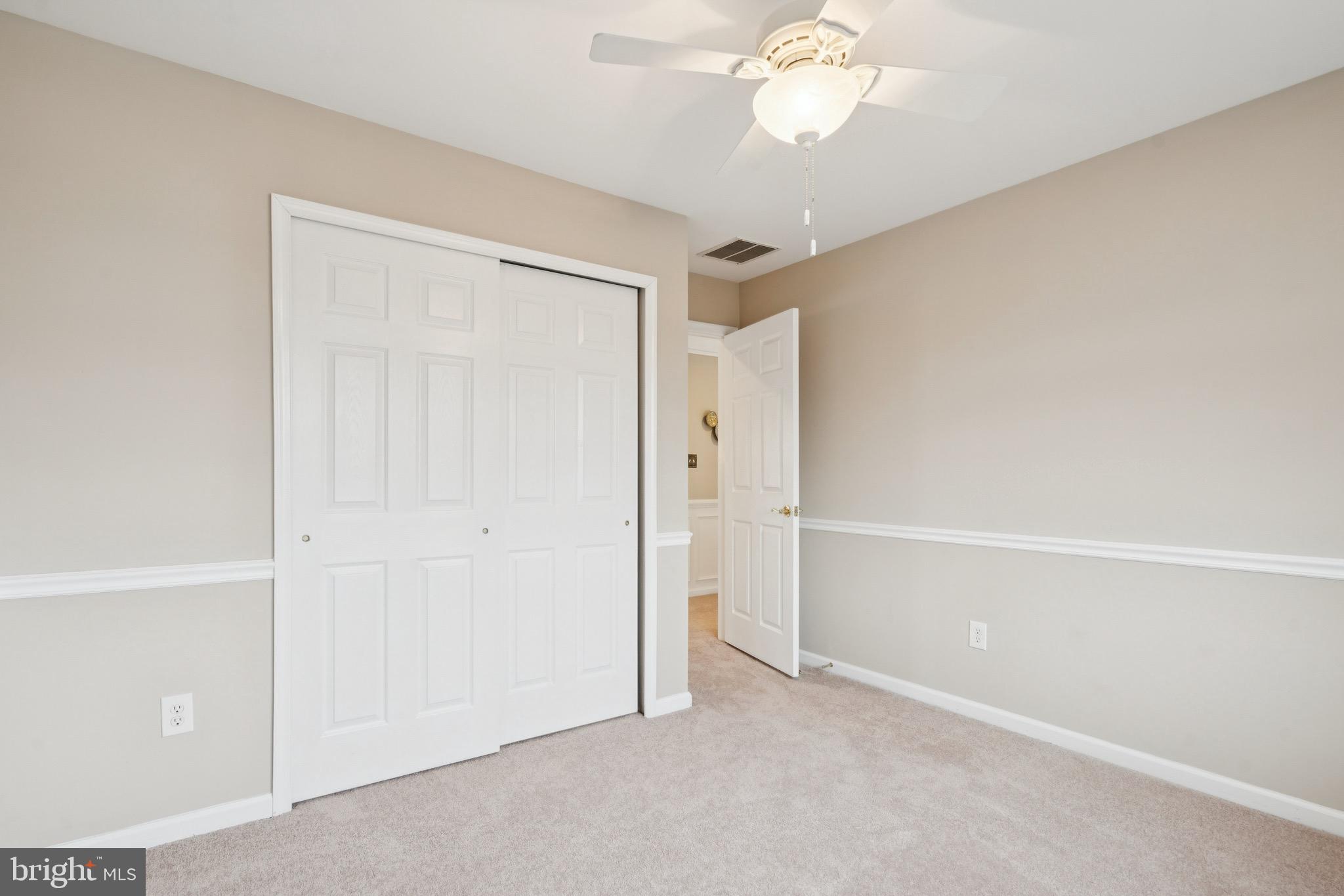 253 Jennings Way Mickleton, NJ 08056 - Photo 32 of 62 an empty room with a chandelier fan and windows