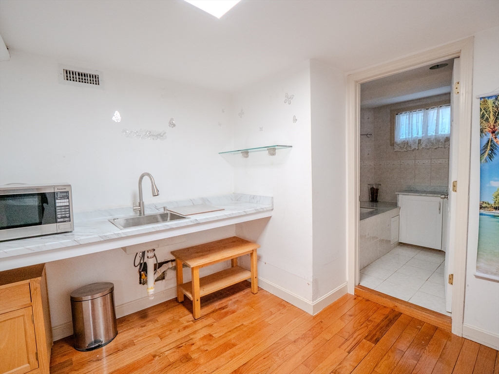 2 Hillside Avenue Somerville, MA 02145 - Photo 23 of 40 a view of a kitchen area with wooden floor and electronic appliances