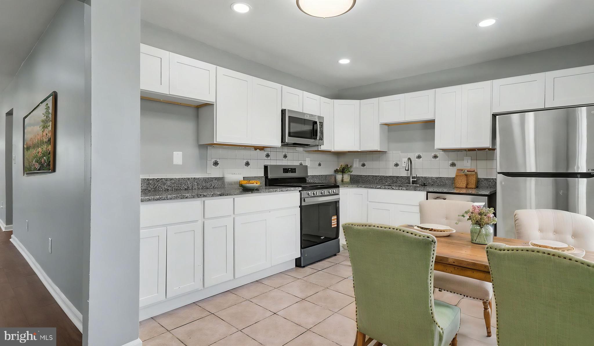 4203 Shell Street Capitol Heights, MD 20743 - Photo 42 of 47 a kitchen with a refrigerator a stove top oven and white cabinets