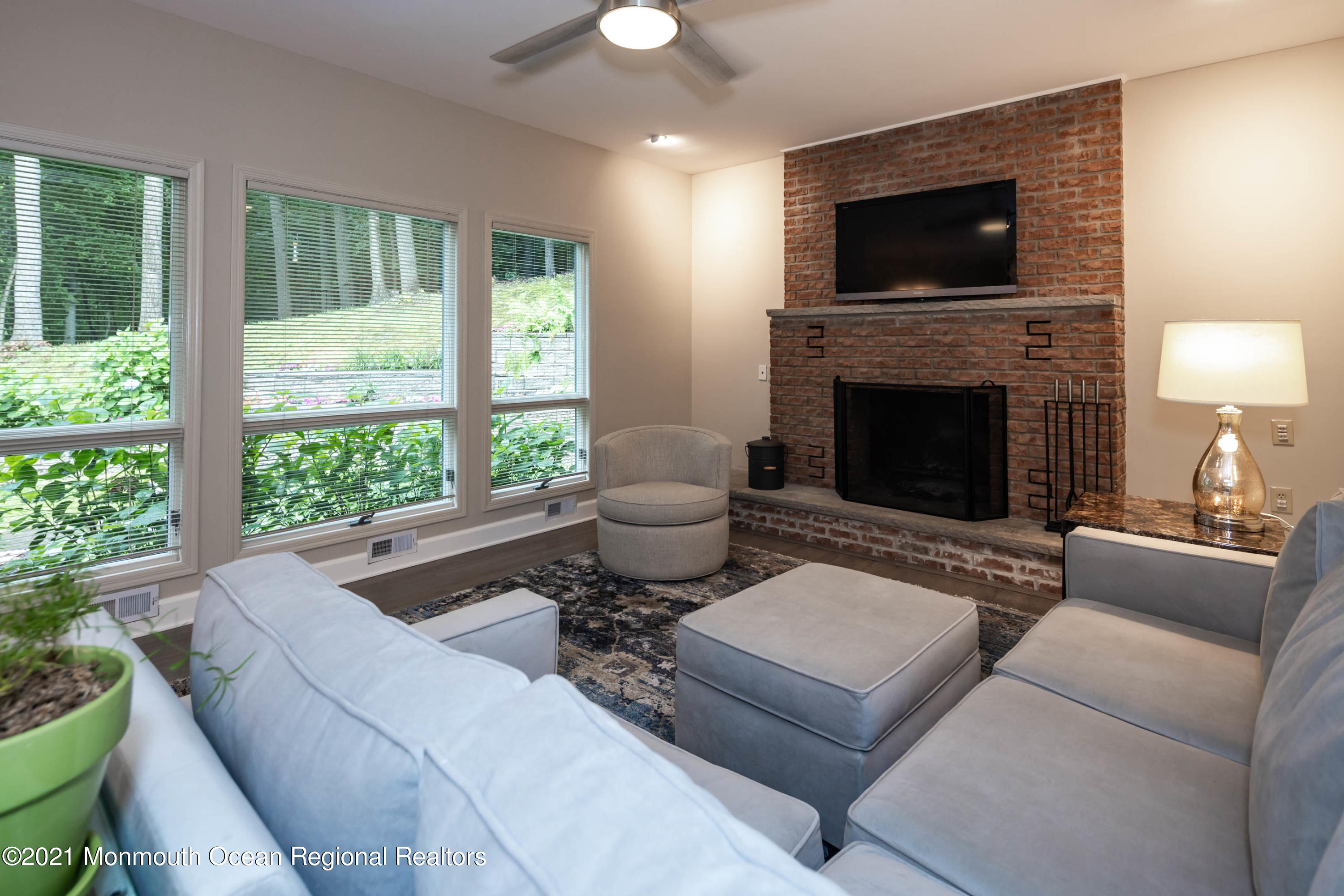 17 Highpoint Road Holmdel, NJ 07733 - Photo 9 of 21 a living room with furniture a flat screen tv and a fireplace