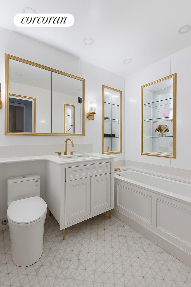 900 5th Avenue, Unit 10C Manhattan, NY 10021 - Photo 11 of 15 a bathroom with a toilet a sink a mirror and a window