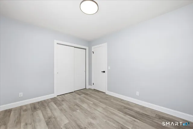 a view of a room with wooden floor and white walls