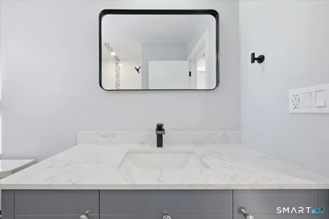 a bathroom with mirror sink and vanity