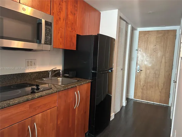 a kitchen with stainless steel appliances granite countertop a refrigerator and a stove top oven