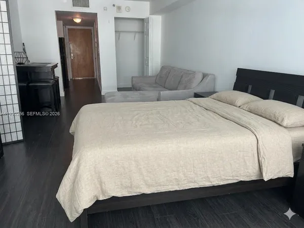 a bedroom with a bed and wooden floor