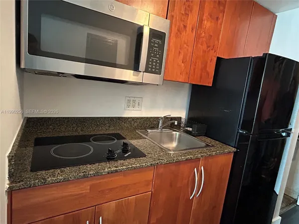 a kitchen with stainless steel appliances granite countertop a sink stove and microwave