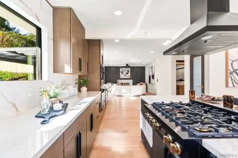 a large kitchen with kitchen island a large window in it