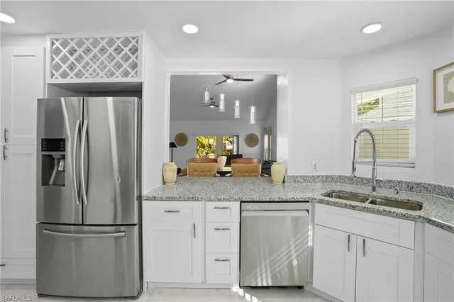 a kitchen with stainless steel appliances granite countertop a refrigerator and a sink
