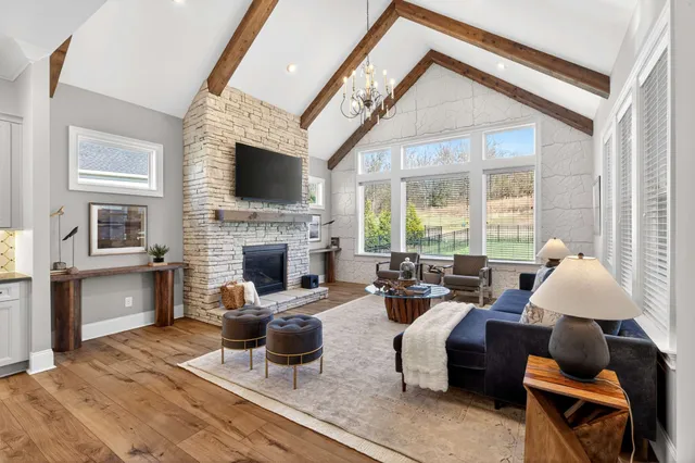 a living room with furniture fireplace and a large window