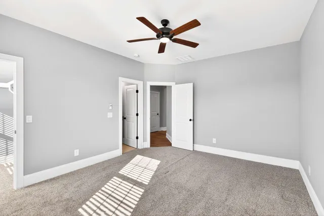 a view of a livingroom with a ceiling fan and wooden floor