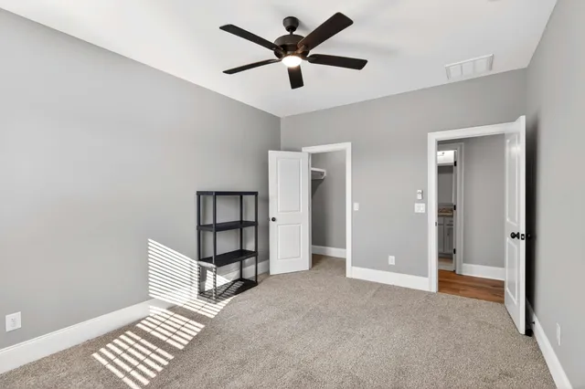 a bedroom with a bed a dresser and painting on the wall