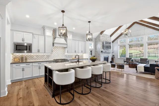 a kitchen with stainless steel appliances granite countertop a kitchen island a stove and a sink