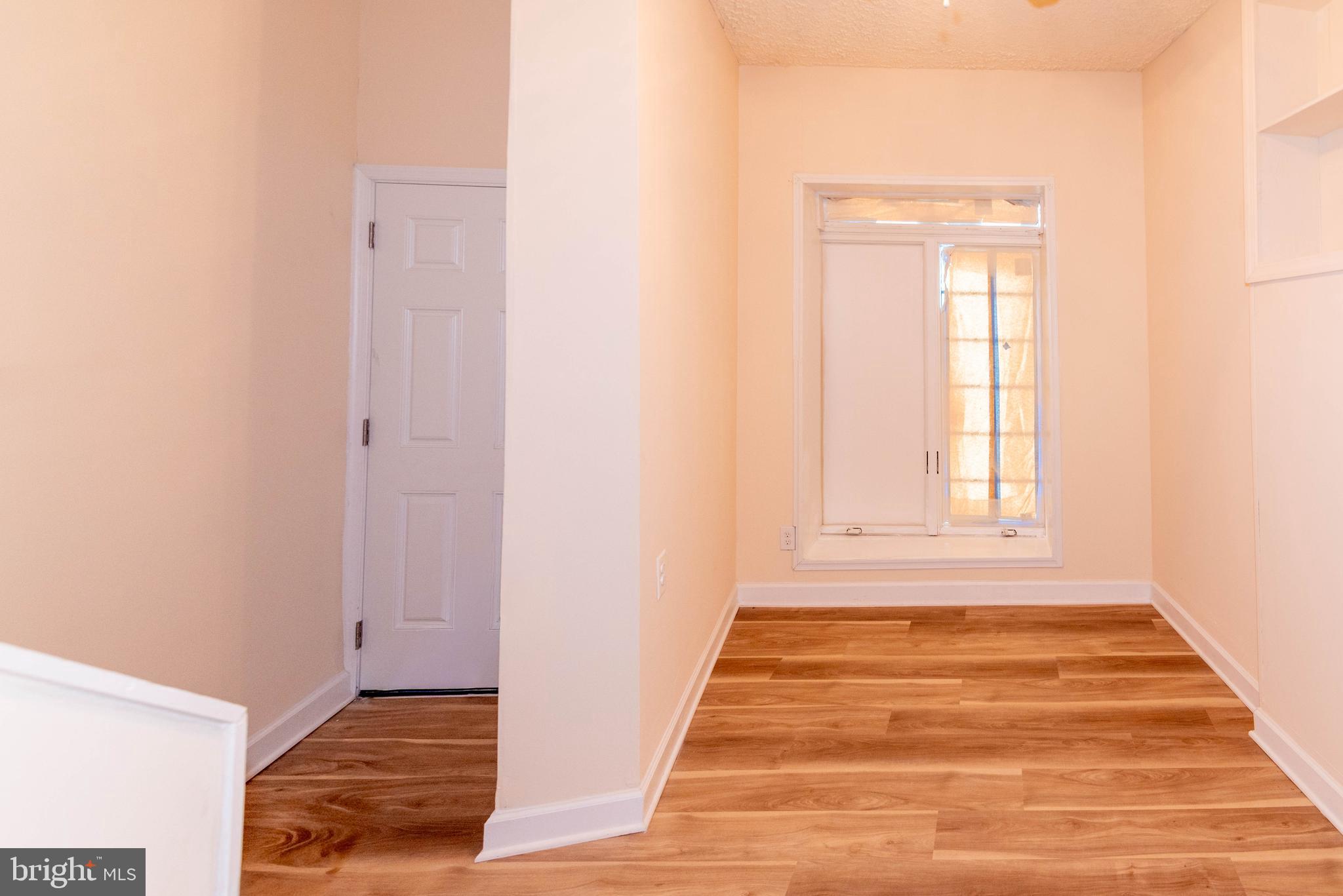 2000 Hollins Ferry Road Baltimore, MD 21230 - Photo 7 of 43 a view of an empty room with wooden floor and a window