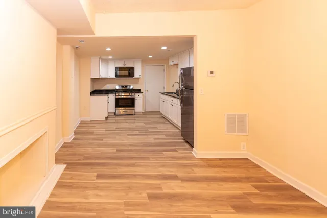 a kitchen with granite countertop white cabinets and refrigerator
