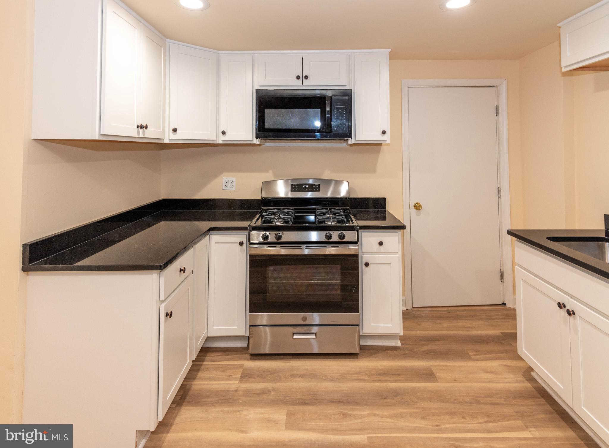 2000 Hollins Ferry Road Baltimore, MD 21230 - Photo 10 of 43 a kitchen with granite countertop a stove top oven microwave and cabinets