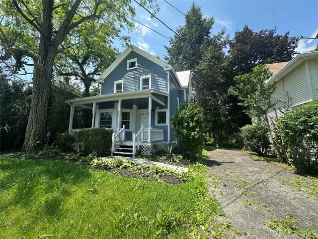 a view of house with a yard and sitting area