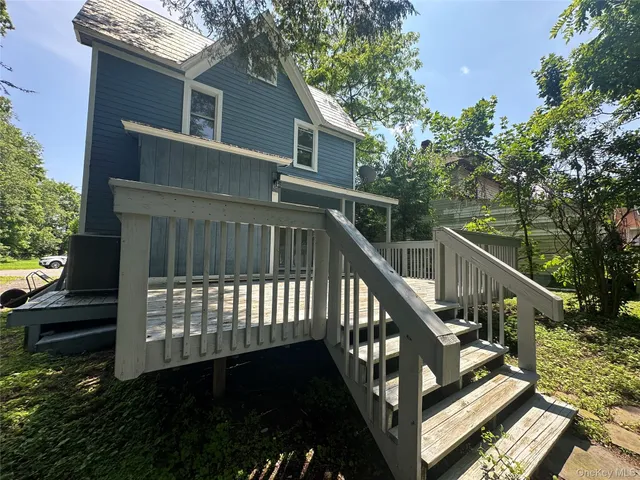 a view of a house with backyard and deck