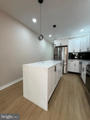 an empty room with wooden floor and white walls