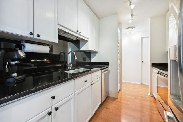 a kitchen with a refrigerator and a stove top oven