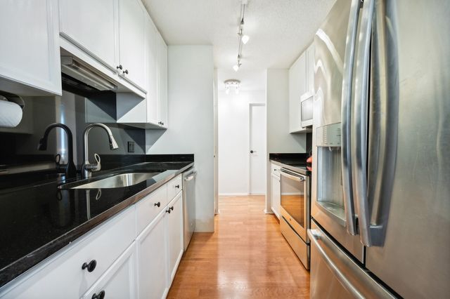 a kitchen with stainless steel appliances granite countertop a refrigerator and a stove