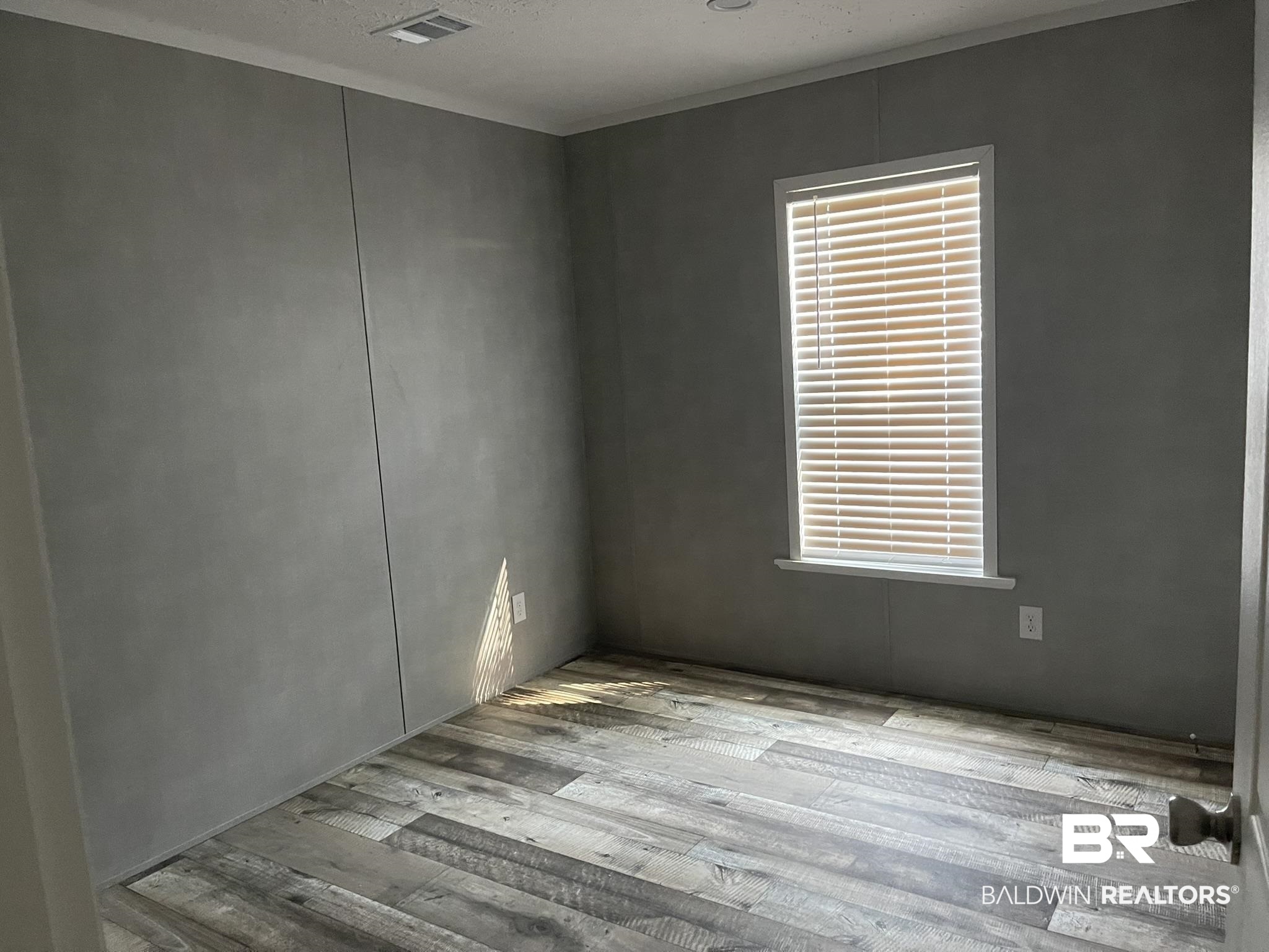9592 Redfish Drive Elberta, AL 36530 - Photo 7 of 8 Spare room featuring hardwood / wood-style floors and a textured ceiling