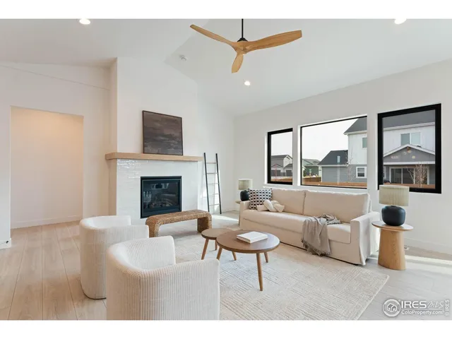 a living room with furniture a fireplace and a floor to ceiling window