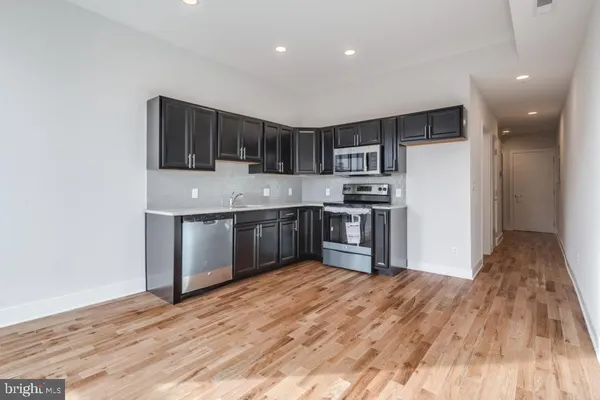 a kitchen with stainless steel appliances granite countertop a sink a stove and a refrigerator