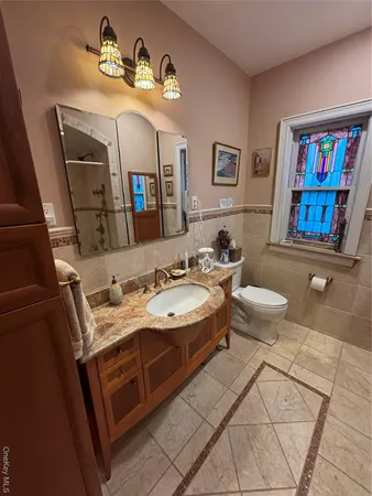 a spacious bathroom with a sink a toilet a mirror and shower