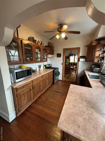 a kitchen with stainless steel appliances kitchen island granite countertop a sink a stove counter space and cabinets