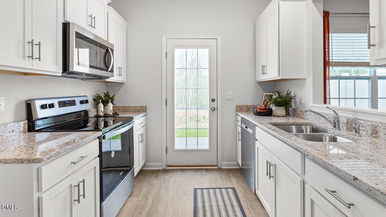 186 Canopy Drive Graham, NC 27253 - Photo 8 of 23 a kitchen with granite countertop a sink a stove and cabinets