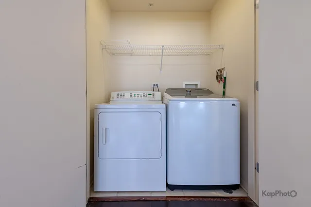 a utility room with wooden floor washer and dryer
