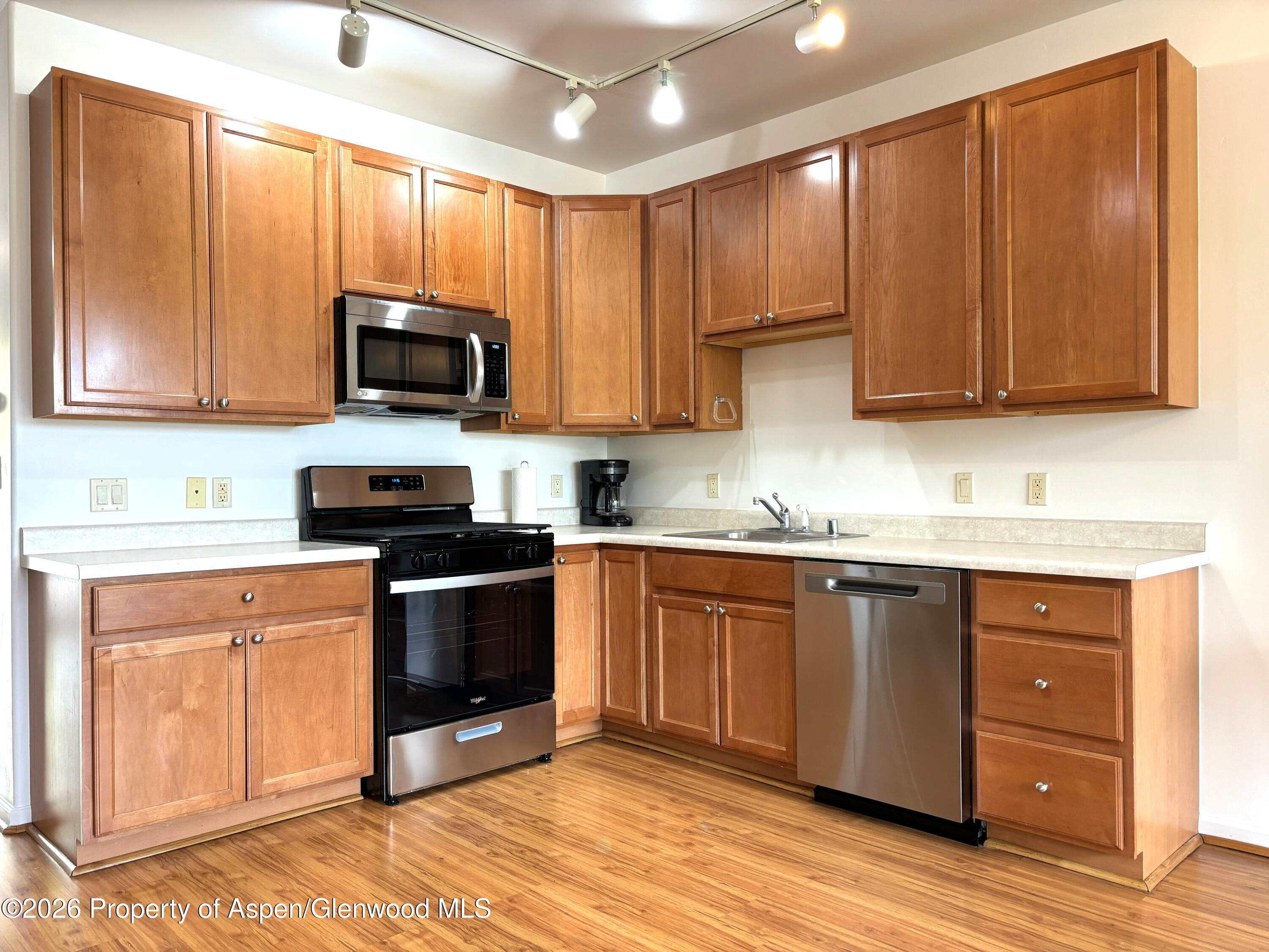 712 Lakeside Drive Basalt, CO 81621 - Photo 4 of 21 a kitchen with granite countertop wooden cabinets a sink and dishwasher