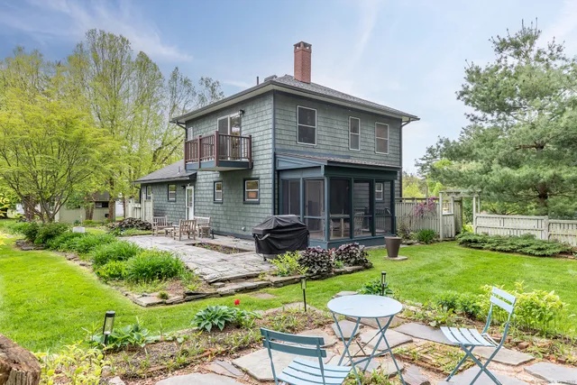 a view of a house with backyard sitting area and garden