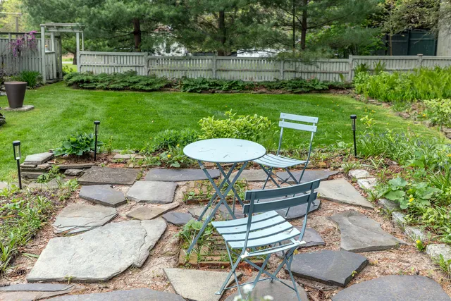 a view of a chairs and table in backyard