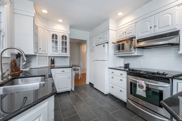 a kitchen with stainless steel appliances a stove sink and cabinets