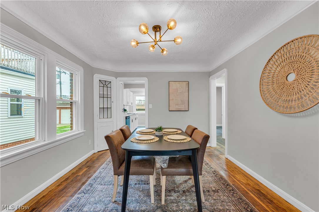 1000 Pennfield Road Cleveland, OH 44121 - Photo 12 of 34 Dining space with a textured ceiling, a chandelier, and dark hardwood / wood-style floors