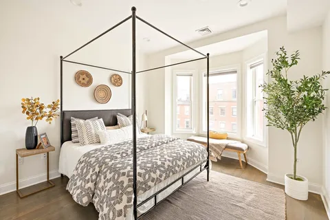 a bedroom with a bed and a potted plant