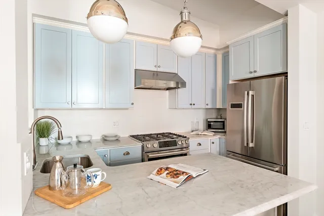 a kitchen with stainless steel appliances granite countertop a stove refrigerator a sink dishwasher with a dining table and chairs