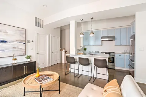 a living room with stainless steel appliances kitchen island granite countertop furniture and a large window